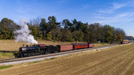 Foto de Una vista aérea de un antiguo pasajero de vapor restaurado - Tren de mercancías que viaja a través de tierras de cultivo en un día de otoño - Imagen libre de derechos