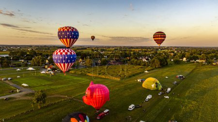 Foto de Bird in Hand, Pennsylvania, 14 de septiembre de 2023 - Una vista aérea de múltiples globos de aire caliente lanzándose y flotando lejos sobre la Pensilvania rural al amanecer en una soleada mañana de verano - Imagen libre de derechos