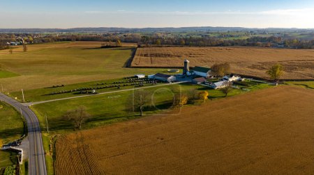 Foto de Capturando la esencia del tiempo de cosecha, esta vista aérea muestra una granja en expansión con campos listos para la cosecha, una instantánea de la vida agrícola y las estaciones cambiantes. - Imagen libre de derechos