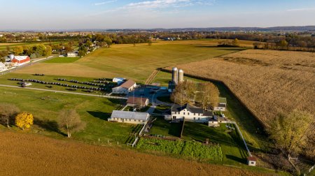 Foto de Ronks, Pennsylvania, 7 de noviembre de 2023 - A medida que el sol se pone, esta vista aérea destaca una granja después de la cosecha, con sus silos y edificios distintivos, que encarnan la esencia de la vida rural y la - Imagen libre de derechos