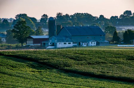 Foto de Ronks, Pennsylvania, EE.UU., 20 de agosto de 2023 - El día se despierta en una granja clásica, con graneros y silos de pie en medio de los campos, un entorno pintoresco para historias de agricultura, patrimonio - Imagen libre de derechos