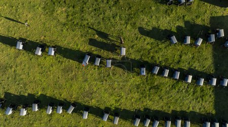 From the sky, the orderly arrangement of Amish buggies casts long shadows on the grass, evoking a sense of community and tradition at days end. during an Amish Wedding