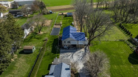 Foto de Gordonville, Pensilvania, Estados Unidos, 9 de abril de 2024 - Vista aérea capturando una propiedad residencial rodeada de árboles y césped verde. - Imagen libre de derechos
