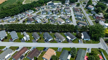 Luftaufnahme eines Vorortmobils, Fertighauses, Fabrikats, Nachbarschaftsparks mit Häuserzeilen, ordentlich getrimmtem Rasen und geparkten Autos