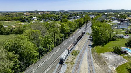 Aerial of a steam engine moving freight in yard to multiple rail tracks.