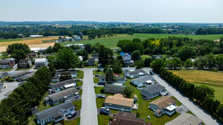 Vue aérienne d'une banlieue Mobile, Préfabriqué, Fabriqué, parc de quartier, avec des rangées de maisons, pelouses soigneusement taillées, et les voitures stationnées