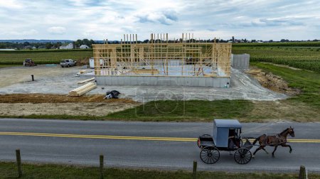Ein Amish-Pferd und ein Buggy passieren Baustelle eines Neubaus