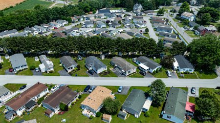 Overhead aerial view of a suburban Mobile, Prefab, Manufactured, neighborhood park, featuring rows of homes, neatly trimmed lawns, and parked cars