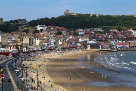 Photo for Scarborough, United Kingdom - June 22, 2022: People walking on the beach and castle in Scarborough, UK on June 22, 2022. - Royalty Free Image