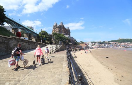 Photo for Scarborough, United Kingdom - June 22, 2022: People walking on the beach and hotel and castle in Scarborough, UK on June 22, 2022. - Royalty Free Image