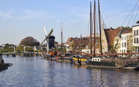 Photo for Boats, drawbridge and windmill along a canal in Leiden, Holland - Royalty Free Image