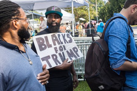 Photo for Atlanta, GA / USA - August 24, 2023:  An African-American man holds a sign reading "Blacks for Trump" as he and others gather outside the Fulton County Jail on August 24, 2023 in Atlanta, GA. - Royalty Free Image