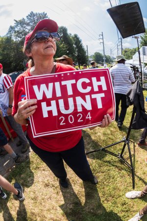 Photo for Atlanta, GA / USA - August 24, 2023:  A female Trump suporter holds sign reading "Witch Hunt 2024" as she and others await Donald Trump's arrest at the Fulton County Jail on August 24, 2023 in Atlanta, GA. - Royalty Free Image