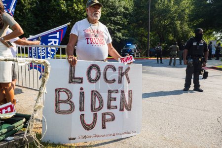 Photo for Atlanta, GA / USA - August 24, 2023:  A man holds a large sign that says "Lock Biden Up" while awaiting Donald Trump's arrest at the Fulton County Jail on August 24, 2023 in Atlanta, GA. - Royalty Free Image