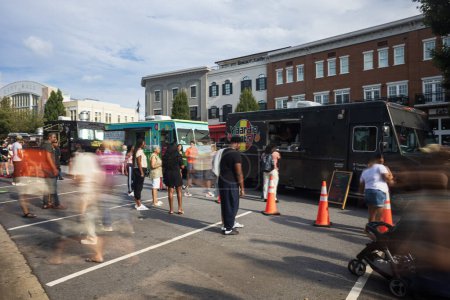 Téléchargez les photos : Suwanee, GA / USA - Le 4 août 2023 : Flou de mouvement des personnes faisant la queue et attendant dans les camions de nourriture, pour l'événement Food Truck Friday le 4 août 2023 à Suwanee, GA. - en image libre de droit