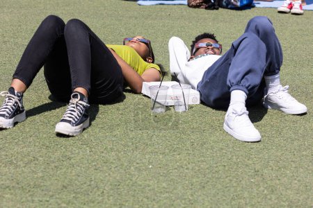 Foto de Atlanta, GA / USA - 8 de abril de 2024: Dos adolescentes yacen en el suelo y miran a través de gafas especiales para ver el eclipse solar total el 8 de abril de 2024 en Atlanta, GA. - Imagen libre de derechos
