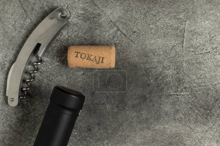 Téléchargez les photos : Du vin tokaji. Bouteille, tire-bouchon et liège sur fond noir. - en image libre de droit