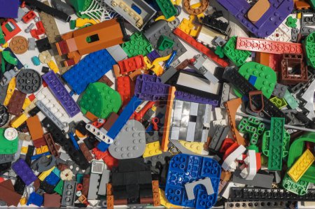 Photo for The photo captures a delightful mess of colorful LEGO bricks, scattered haphazardly across a flat surface. The various pieces form a kaleidoscope of colors and shapes, with bright reds, blues, yellows, greens, and oranges creating a vibrant and playf - Royalty Free Image