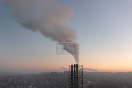 Photo for In this photo, a towering pipe releases thick smoke into the atmosphere, raising concerns about potential environmental impact and health hazards. The pipe stands as a testament to the industrialization and progress of modern society, but also serves - Royalty Free Image