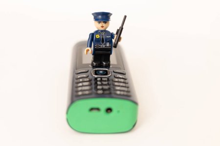 Téléchargez les photos : Un policier jouet sur un téléphone portable. Protection des données personnelles des utilisateurs. Lutte contre la cybercriminalité - en image libre de droit