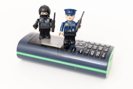 Téléchargez les photos : Des policiers jouant sur un téléphone portable. Protection des données personnelles des utilisateurs. Lutte contre la cybercriminalité - en image libre de droit