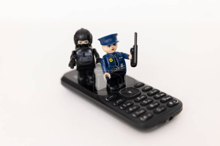 Téléchargez les photos : Des policiers jouant sur un téléphone portable. Protection des données personnelles des utilisateurs. Lutte contre la cybercriminalité - en image libre de droit