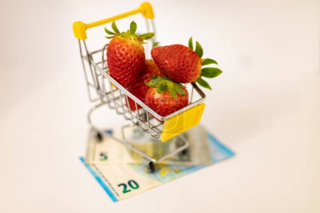 Strawberries in a basket on banknotes. Rising food prices due to the war in Ukraine