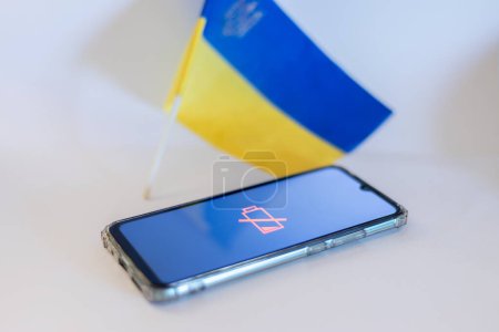 Discharged mobile phone against the background of the flag of Ukraine