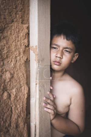 Porträt eines armen kleinen thailändischen Jungen, verloren in tiefen Gedanken, Armut, Arme Kinder, Kriegsflüchtlinge, Gewalt gegen Kinder.