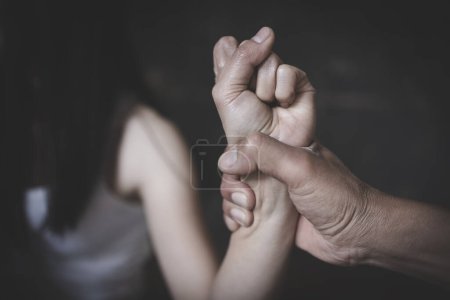 Foto de Mujer víctima de violencia doméstica y abuso. El marido intimida a su esposa. Hombre golpeando a su esposa ilustrando violencia doméstica. - Imagen libre de derechos