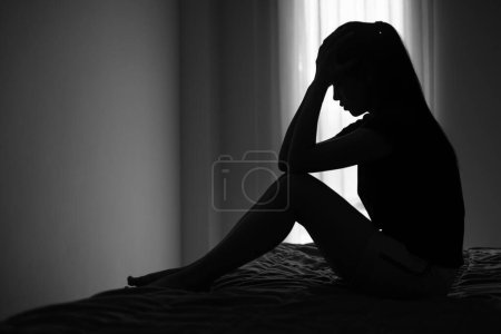 Téléchargez les photos : Silhouette d'une femme présentant des symptômes de dépression et de tristesse, Anxiété, Problèmes familiaux, Malade mental, Violence domestique - en image libre de droit