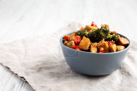 Homemade One-Pan Chicken And Broccoli Stir-Fry in a Bowl, side view. Copy space.