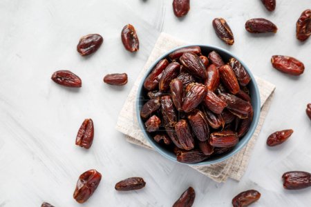 Photo for Pitted Organic Dates in Bowl on gray background, top view. Flat lay, overhead, from above. - Royalty Free Image