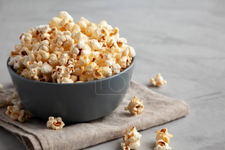Hausgemachtes Mais-Popcorn mit Salz in einer Schüssel, Seitenansicht. Raum für Text.