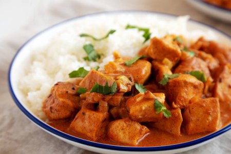 Hausgemachtes Easy Indian Butter Chicken mit Reis auf einem Teller, niedriger Blickwinkel. Nahaufnahme.