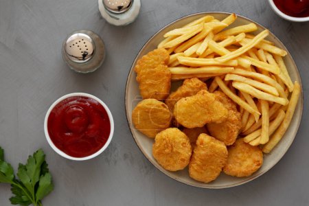 Téléchargez les photos : Nuggets de poulet maison et frites avec ketchup sur fond gris, vue sur le dessus. Couché plat, au-dessus, d'en haut. - en image libre de droit