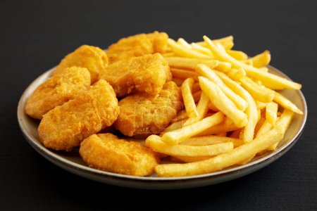 Photo for Homemade Chicken Nuggets and French Fries with Ketchup on black background, side view. Close-up. - Royalty Free Image