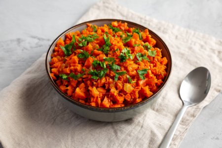 Téléchargez les photos : Riz aux carottes fumé maison avec persil dans un bol, vue latérale. - en image libre de droit