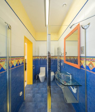 Foto de Moderno interior de baño en apartamento de lujo. Azul y amarillo. Cabina de ducha de vidrio. - Imagen libre de derechos