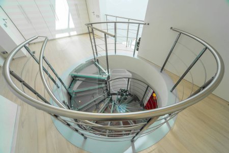 Téléchargez les photos : Intérieur moderne de maison privée de luxe. Escalier en colimaçon en verre et métal. - en image libre de droit