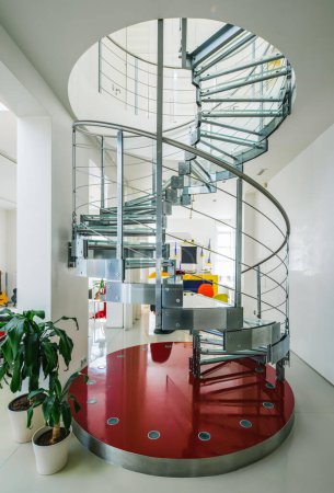Foto de Escalera de caracol hecha de metal y vidrio en casa privada de lujo. Interior blanco moderno. Sala de estar. - Imagen libre de derechos