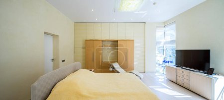 Photo for Modern interior of bedroom in luxury apartment. Private house. Yellow tones. Cozy bed. - Royalty Free Image