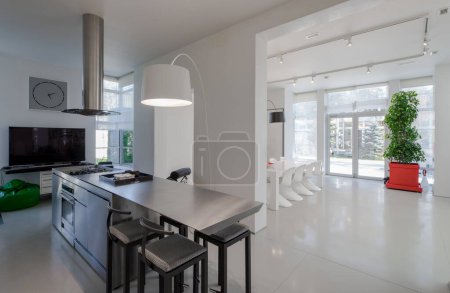 Photo for Modern white interior of spacious private house. Kitchen and dinner room. Table and chairs. - Royalty Free Image