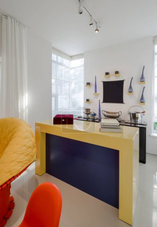 Foto de Moderno interior de apartamento de lujo. Paredes blancas. Yelow, sillas naranjas. Libros en la mesa. - Imagen libre de derechos