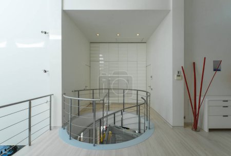 Téléchargez les photos : Intérieur moderne du hall dans une maison privée de luxe. Escalier en colimaçon en verre et métal. Armoire blanche. - en image libre de droit