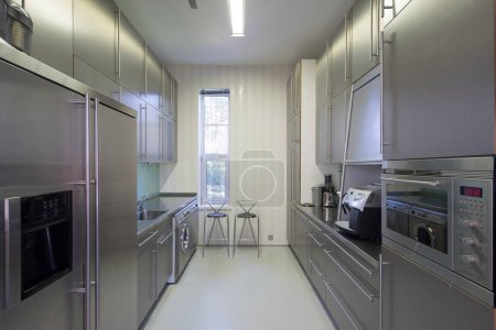 Téléchargez les photos : Intérieur moderne de cuisine en métal dans un appartement de luxe. Appareils ménagers. Machine à laver. - en image libre de droit