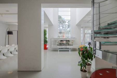 Téléchargez les photos : Intérieur moderne de maison privée de luxe. Séjour spacieux avec sol blanc et murs. Escalier en spirale. - en image libre de droit