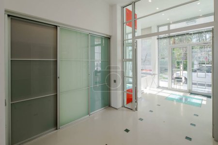 Foto de Moderno interior de amplio hall en casa privada de lujo. Puertas correderas de vidrio. Luz del día. - Imagen libre de derechos