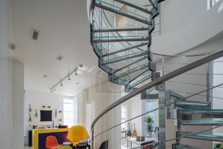 Photo for Modern interiro of luxury private house. Glass and metal spiral staircase. White living room. - Royalty Free Image