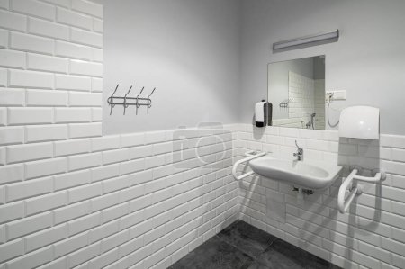 Photo for The interior of bathroom with facilities for the disabled. White bricks. Grey tile. - Royalty Free Image